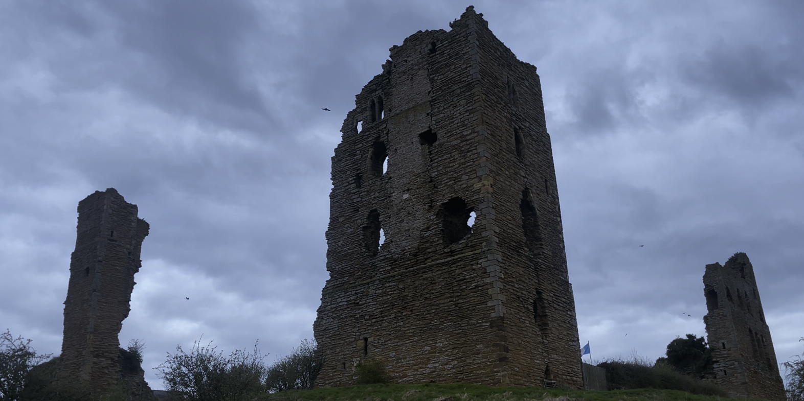 A stone tower with holes in the middle
Description automatically generated
